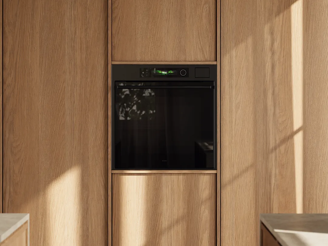 Built-in black oven integrated into a light oak kitchen cabinet wall Built-in black oven integrated into a light oak kitchen cabinet wall