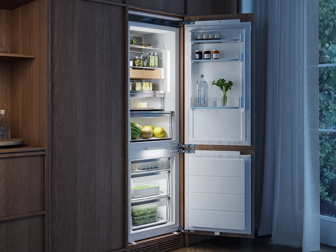 ASKO built-in combi fridge freezer with illuminated interior, wooden drawer details and fresh food storage in a wood kitchen.