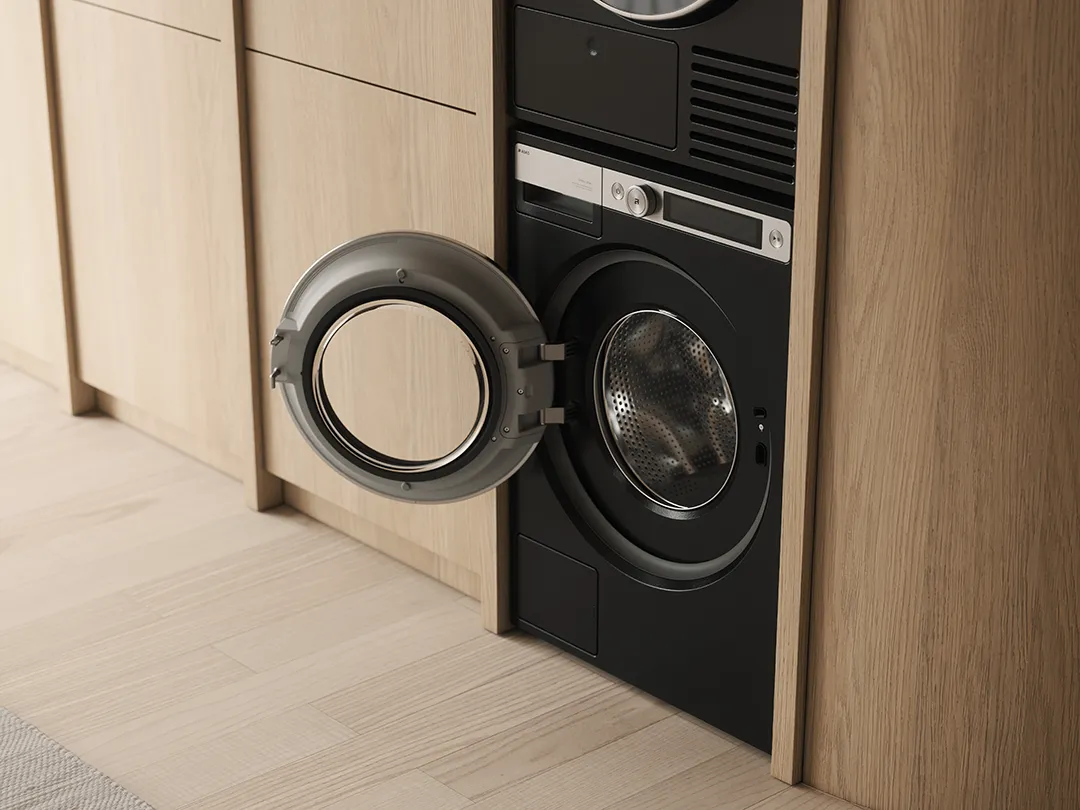 ASKO washing machine in graphite black with open drum door and integrated cabinet installation ASKO washing machine in graphite black with open drum door and integrated cabinet installation