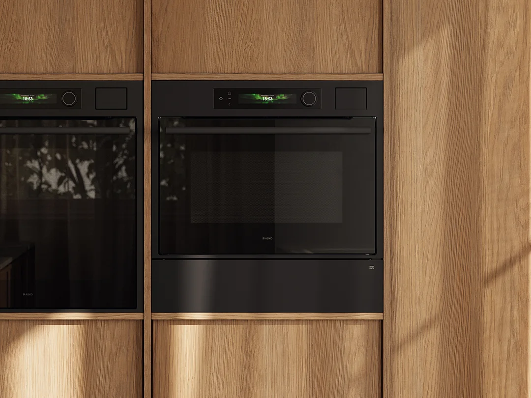 ASKO Craft Frame oven and vacuum drawer in graphite black integrated in a light wood kitchen cabinet ASKO Craft Frame oven and vacuum drawer in graphite black integrated in a light wood kitchen cabinet