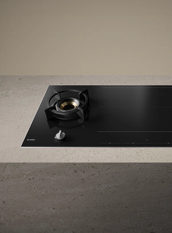 Hybrid gas and induction cooktop in black on a stone countertop. Hybrid gas and induction cooktop in black on a stone countertop.