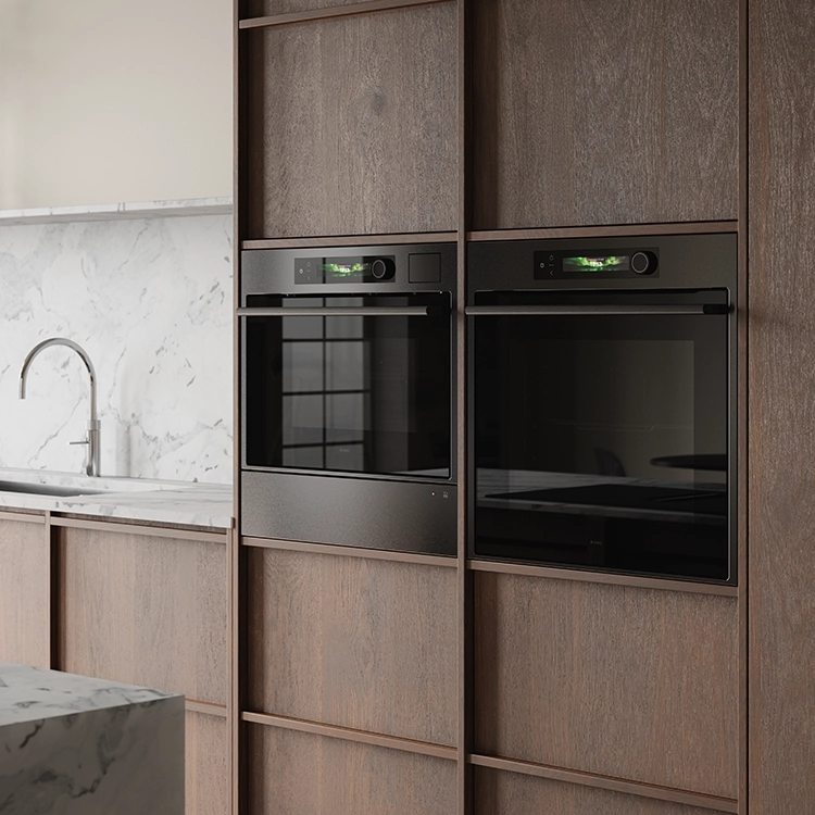 ASKO black steel built-in ovens in a dark wood kitchen. ASKO black steel built-in ovens in a dark wood kitchen.